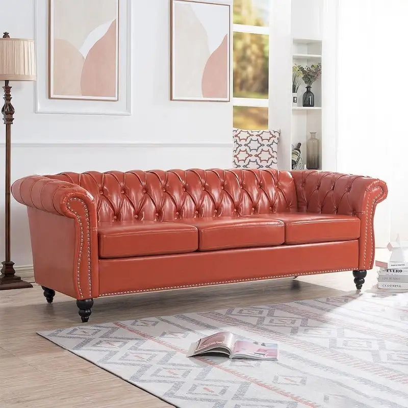 84.65 Divano Chesterfield in finta pelle trapuntata con braccioli arrotolati