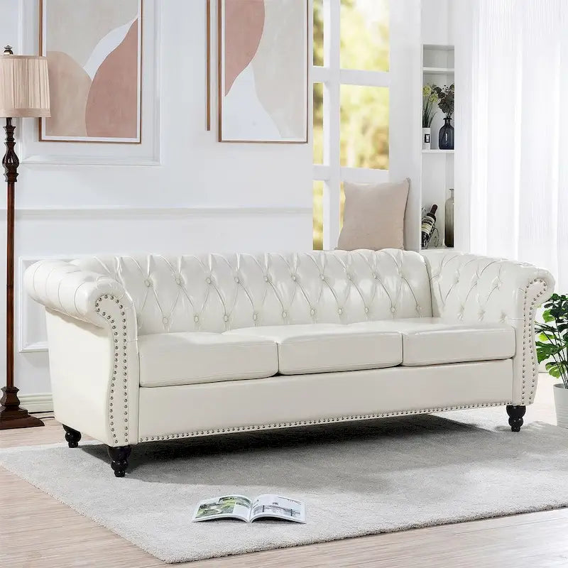 84.65 Divano Chesterfield in finta pelle trapuntata con braccioli arrotolati
