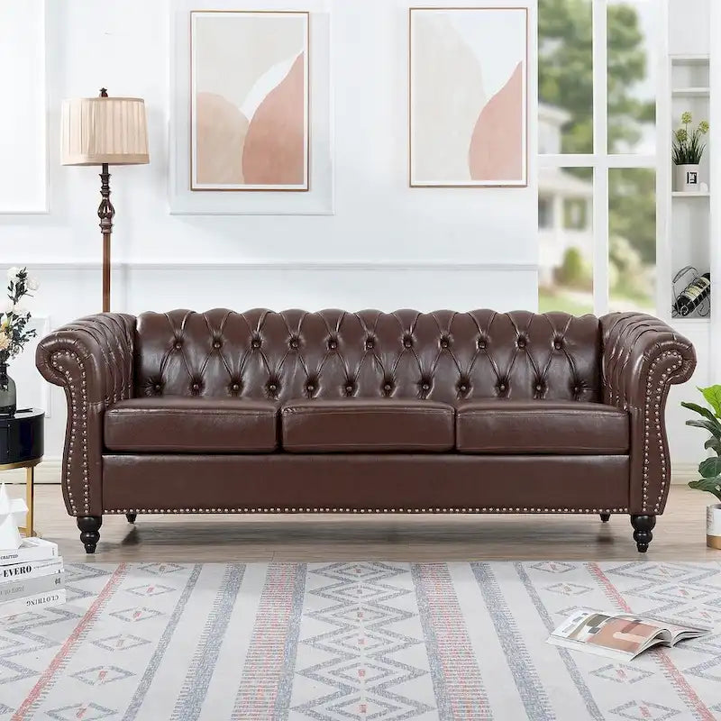 84.65 Divano Chesterfield in finta pelle trapuntata con braccioli arrotolati