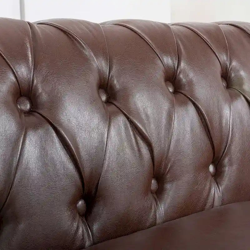 84.65 Divano Chesterfield in finta pelle trapuntata con braccioli arrotolati