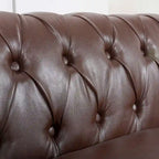 84.65 Divano Chesterfield in finta pelle trapuntata con braccioli arrotolati