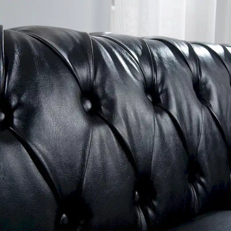 84.65 Divano Chesterfield in finta pelle trapuntata con braccioli arrotolati