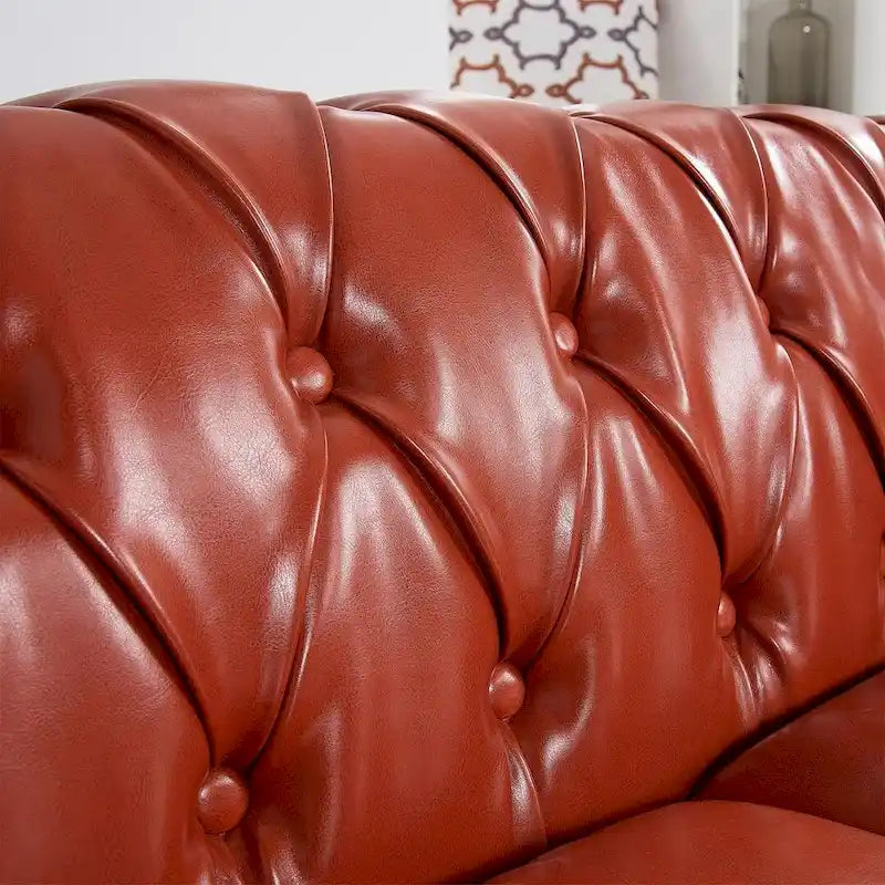 84.65 Divano Chesterfield in finta pelle trapuntata con braccioli arrotolati